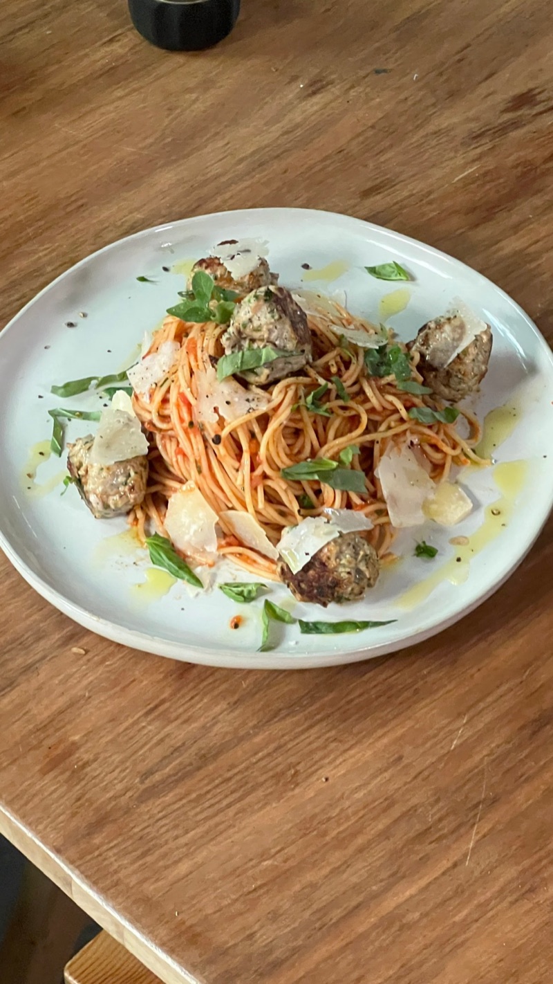 Spaghetti with tiny meatballs, shaved parmesan, and basil